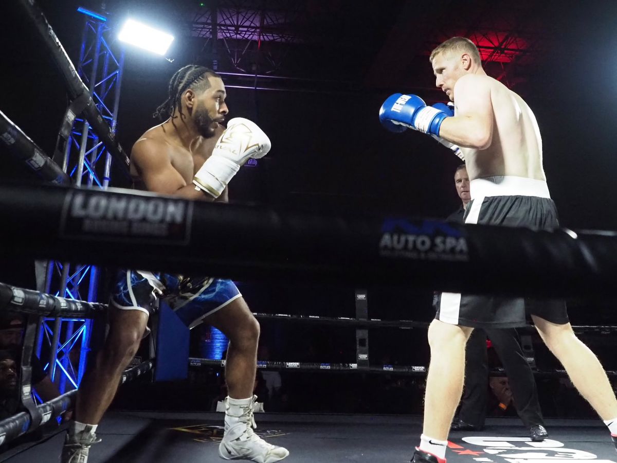 Two fighters circle each other in the ring under the floodlights